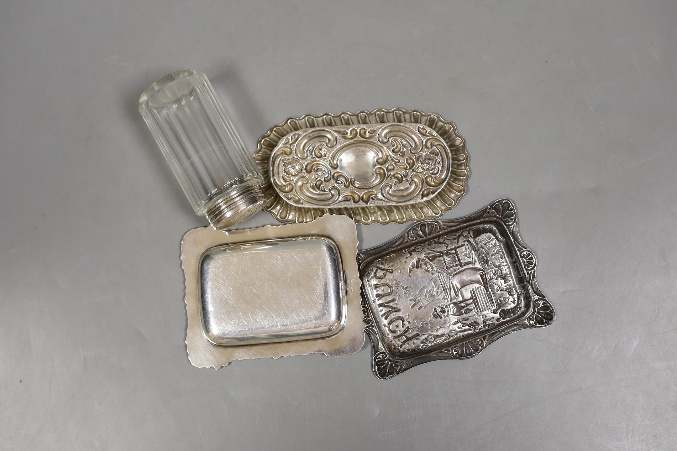 A late Victorian repousse silver 'Mr Punch' pin dish, Saunders & Shepherd, Birmingham, 1894, 10.7cm, one other silver dish, a silver mounted toilet jar and a plated small dish.